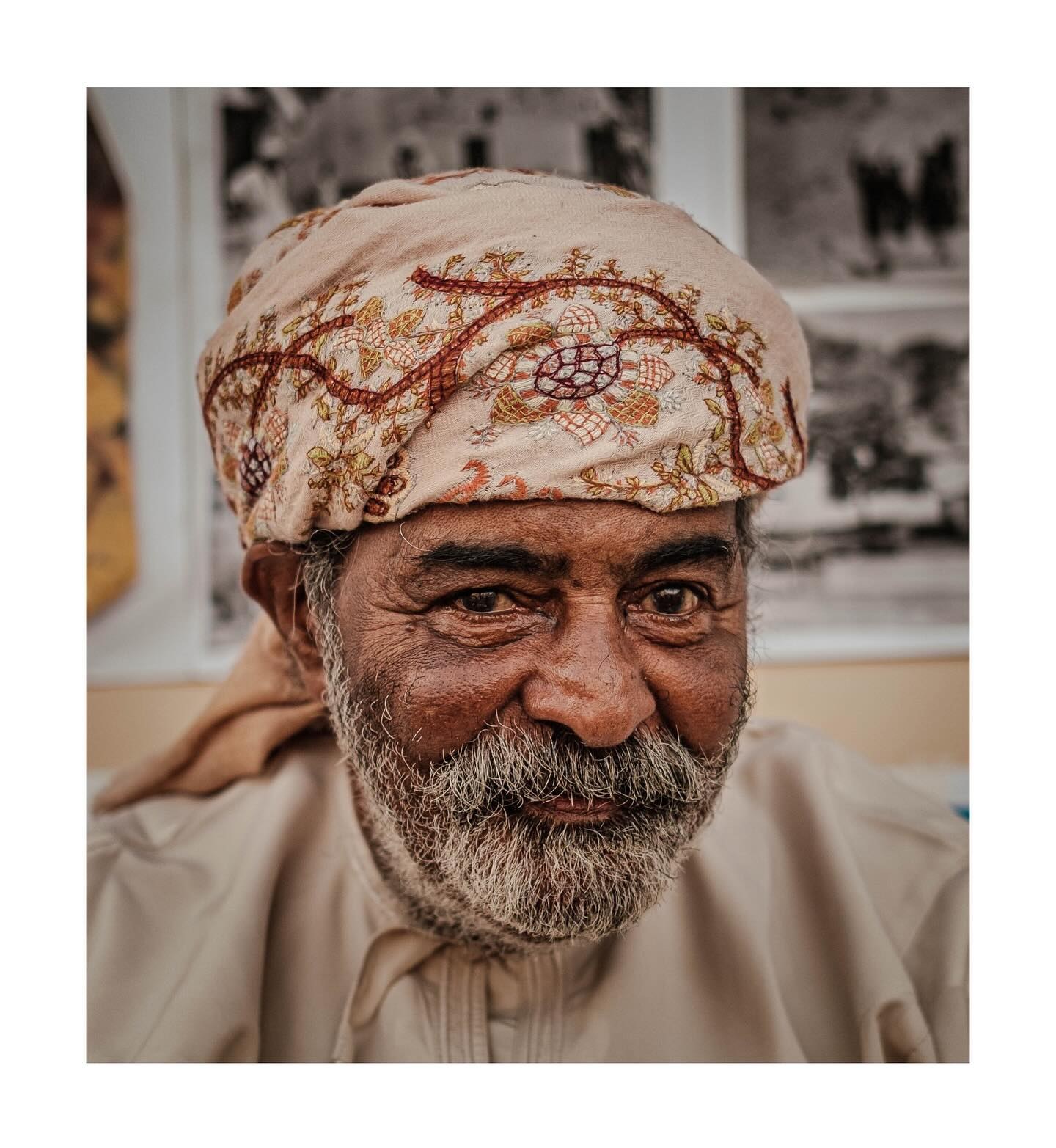Portrait of a smiling man in an embroidered head wrap