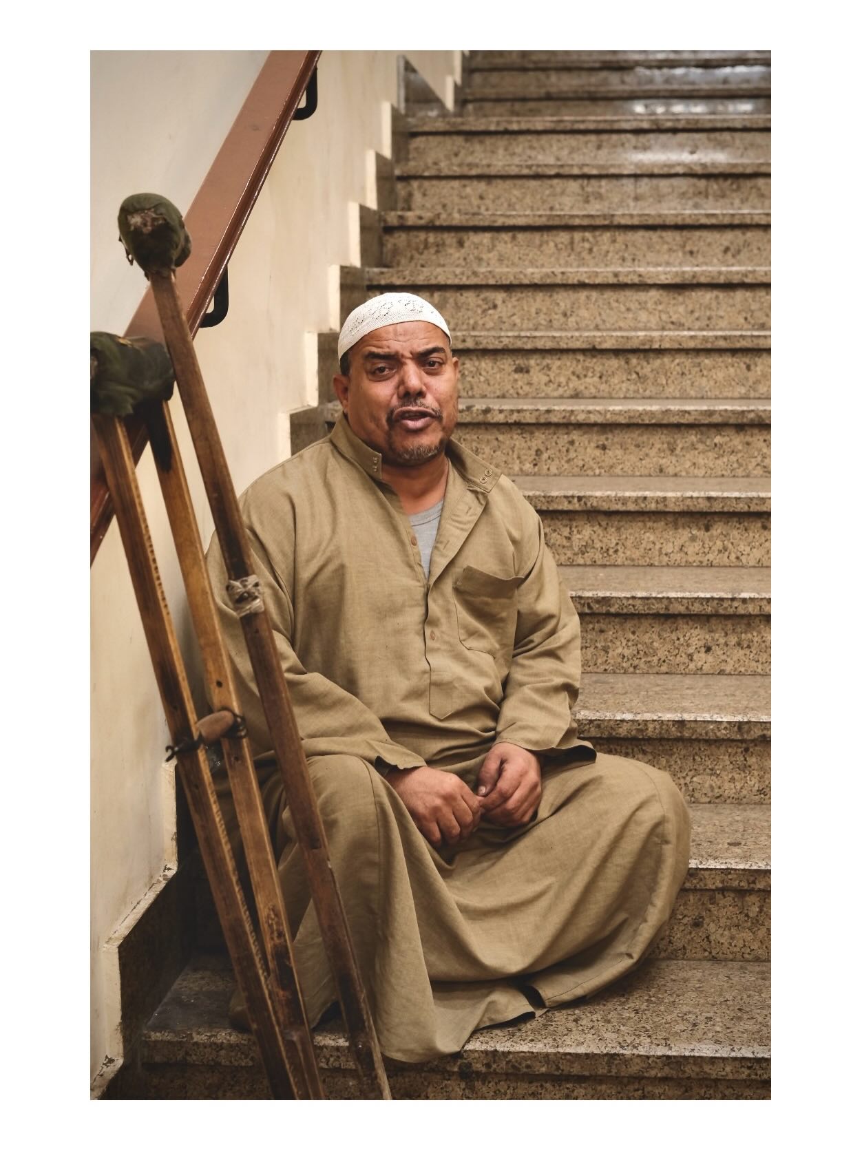 Man seated beside a staircase