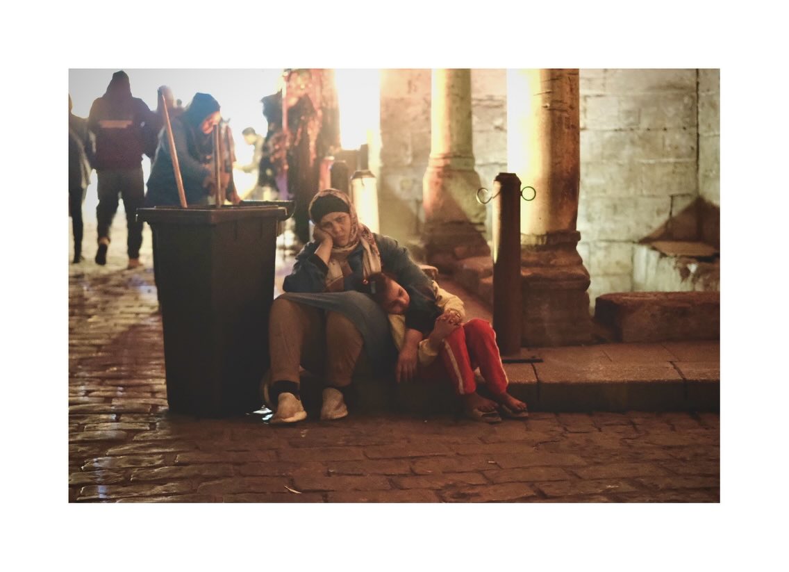 People seated on stone steps at dusk