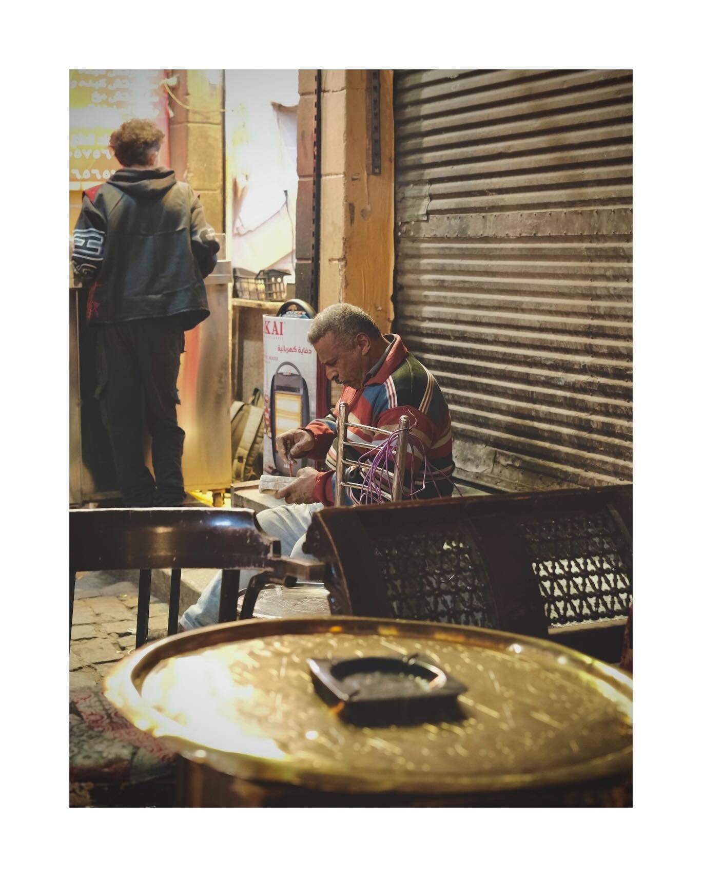 Man seated beside a market walkway