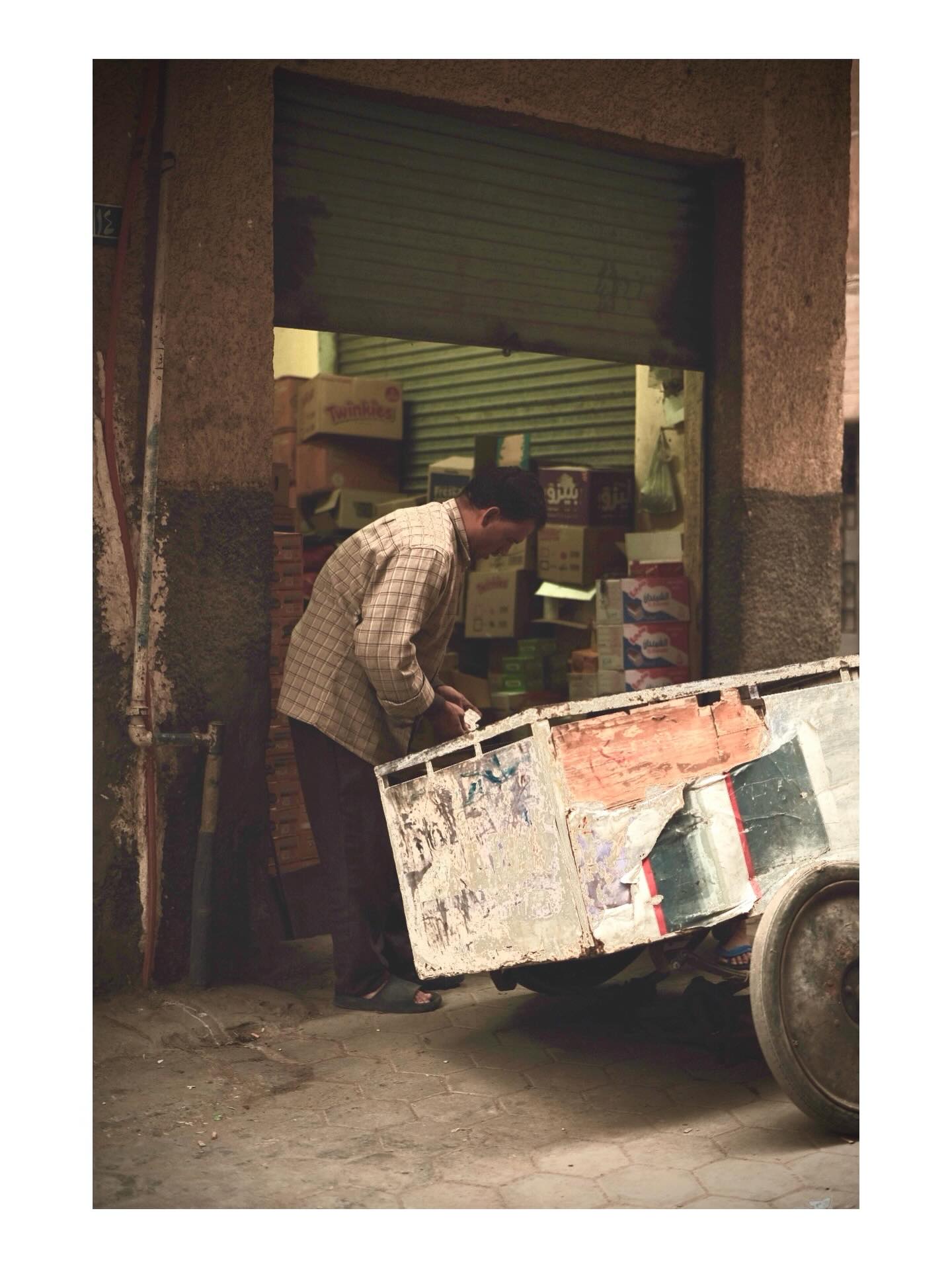 Worker handling a cart outside a shop