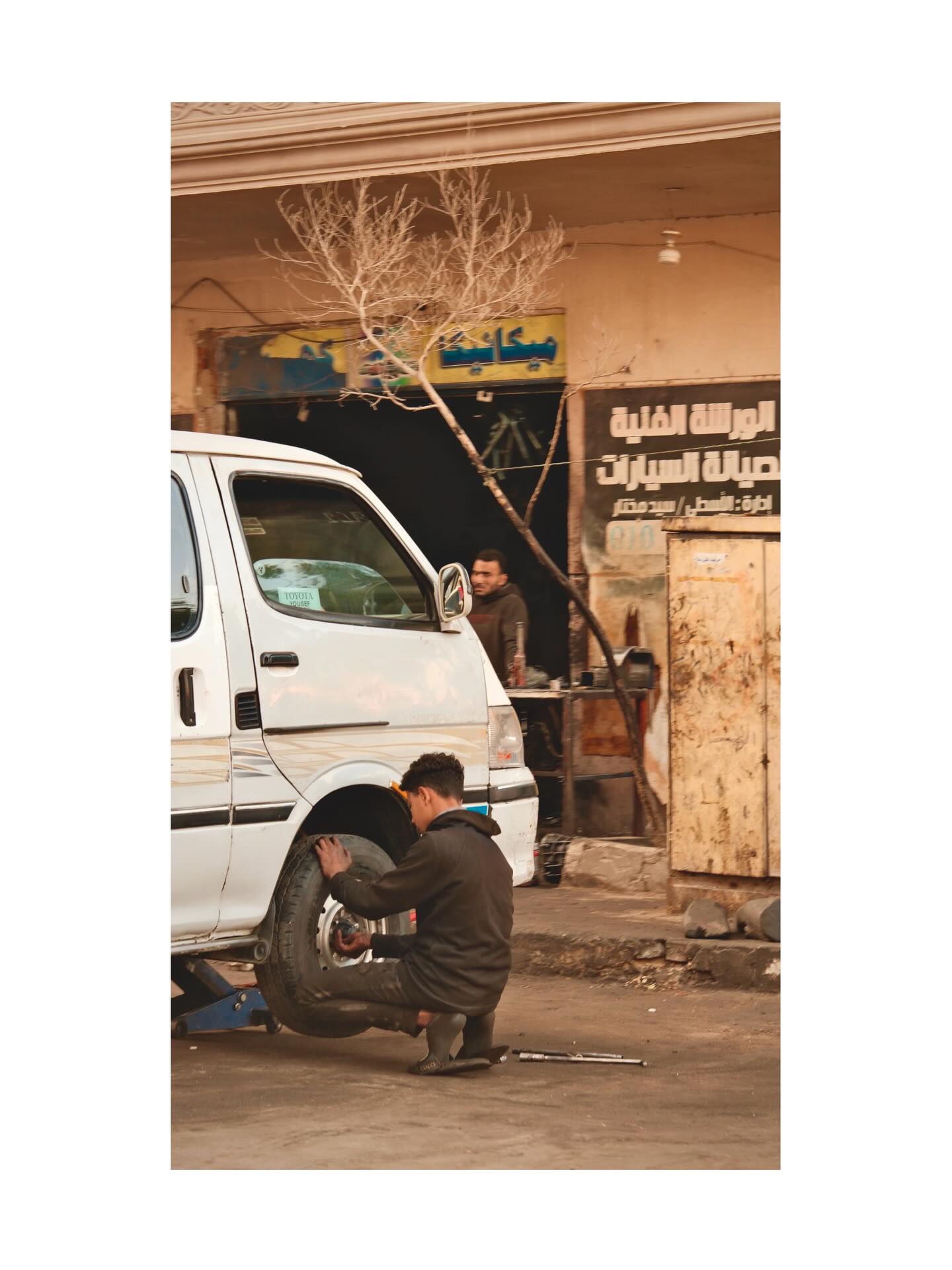 Mechanic working on a wheel beside a van