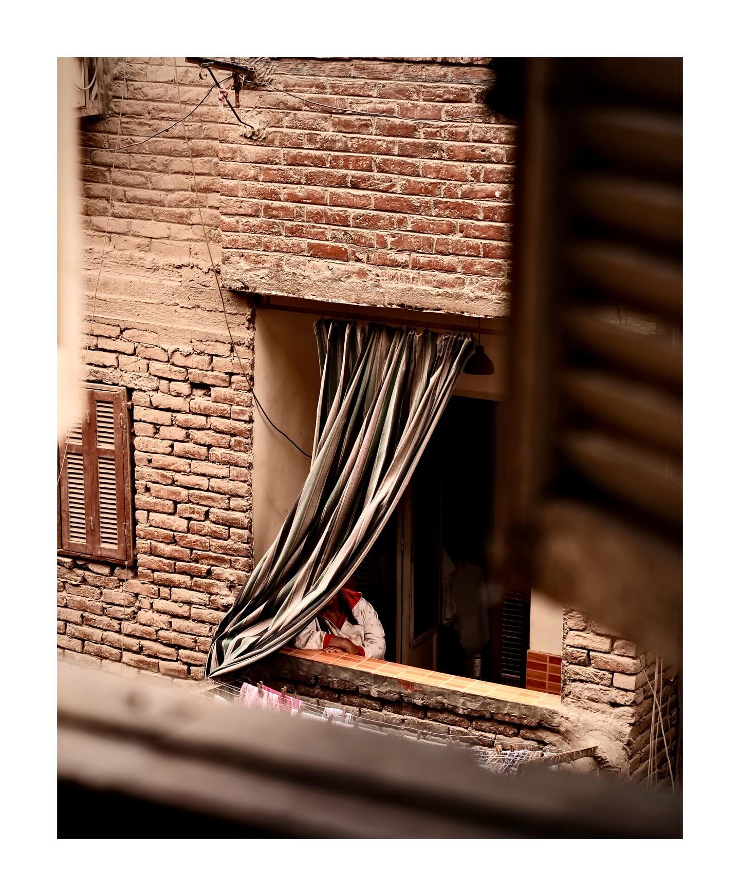 Child at a window in a brick building