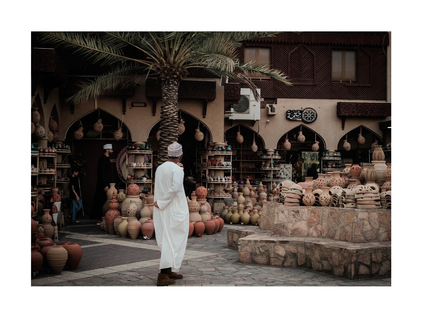 Man walking past a pottery shop