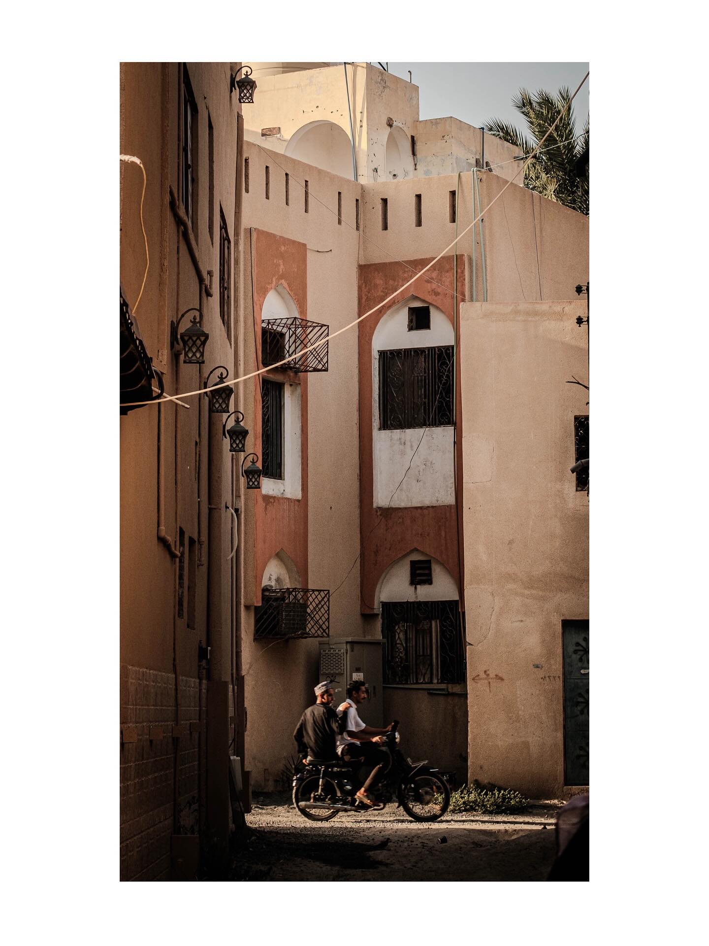 Bicycle and rider beneath tall buildings