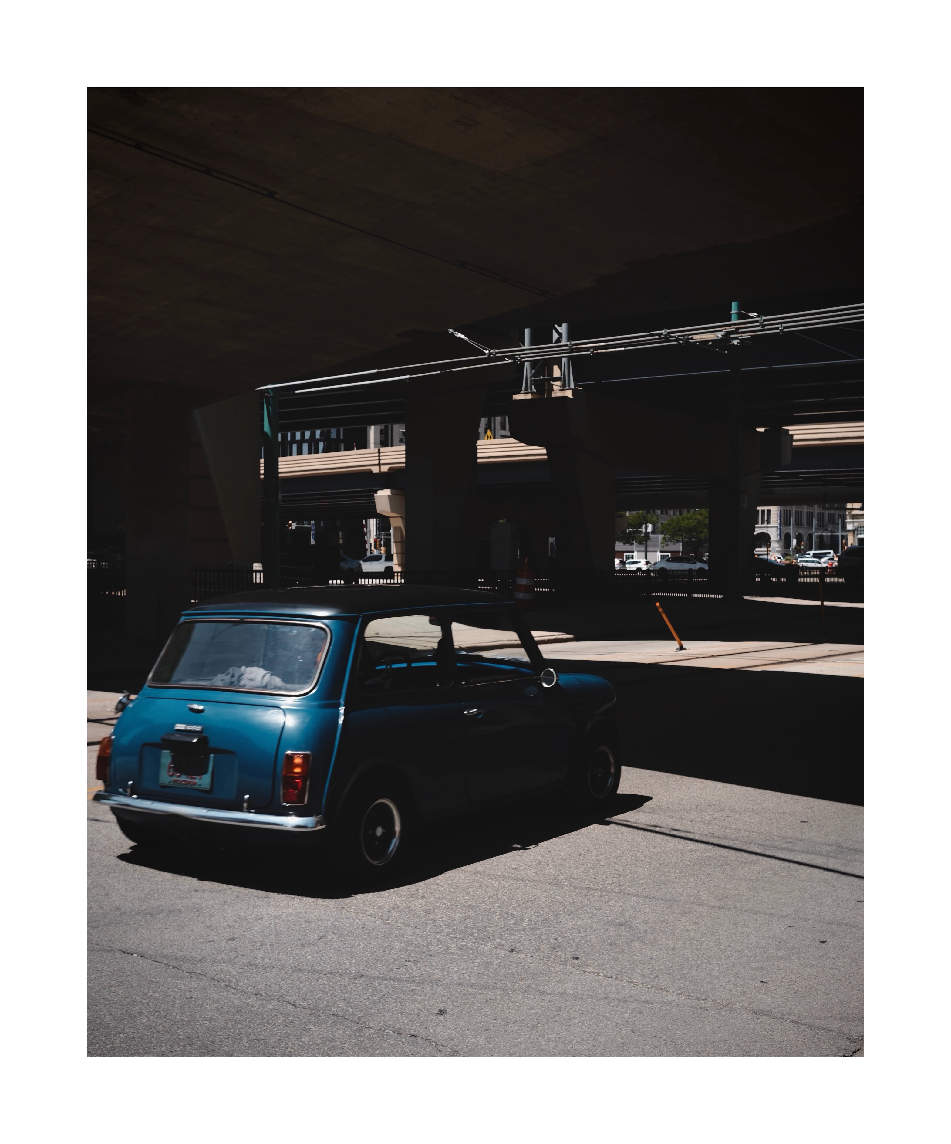 Blue car in a patch of sunlight
