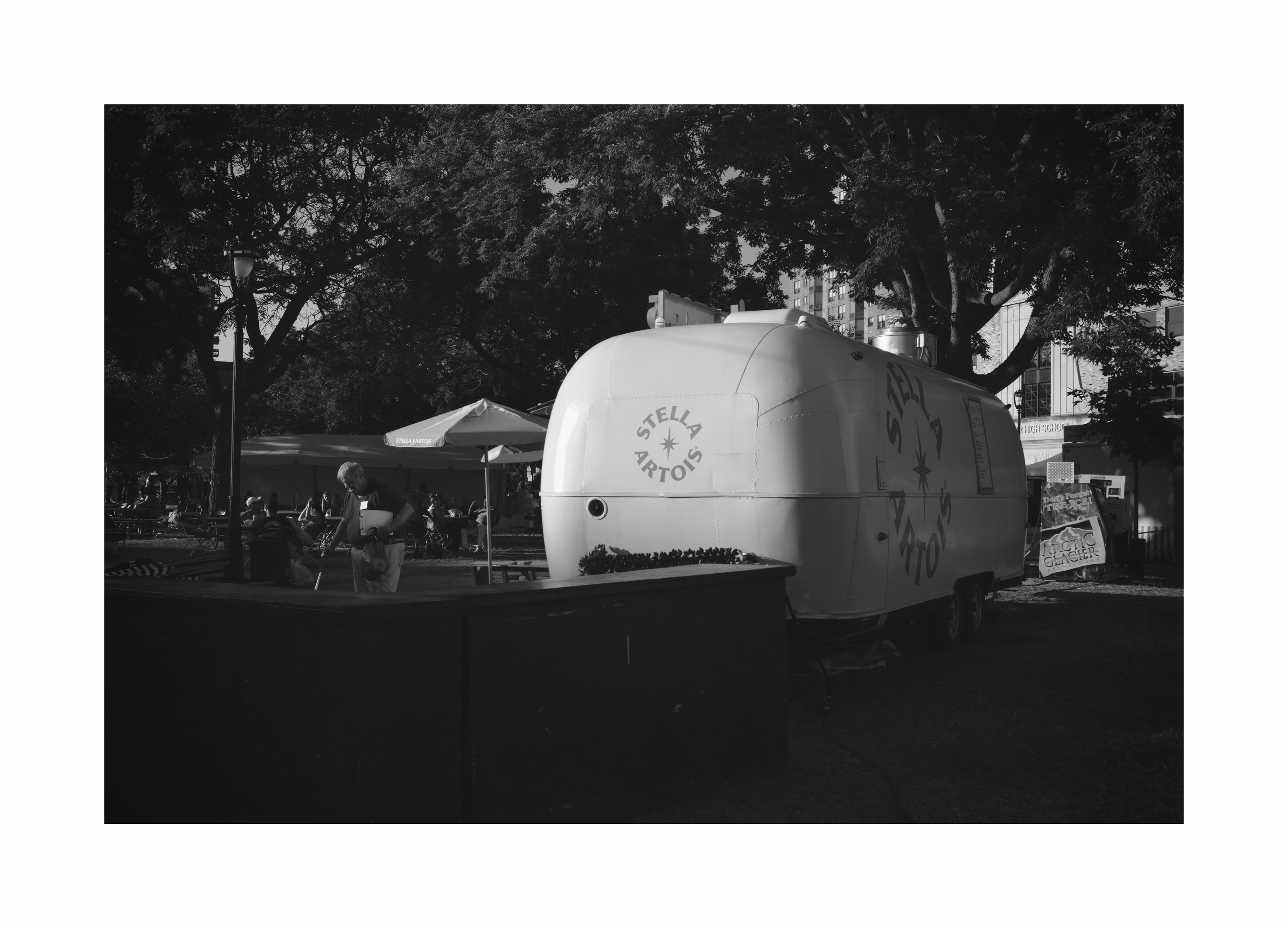 Trailer and people beneath trees